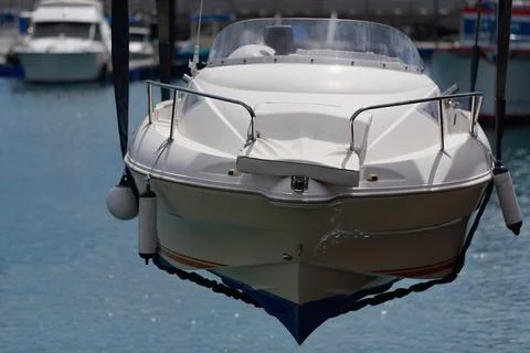 White boat is rising from the sea by using crane Stock Photos