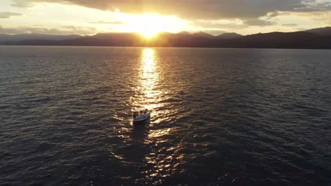 A white boat in the sea against the backdrop of sunset and mountains Stock Footage 155608604
