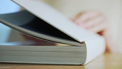 White book on a wooden table. Reading literature during rest. Education Video stock 155382955