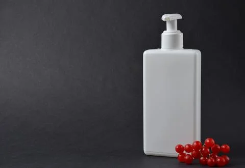 White bottle on a black background. Stock Photos
