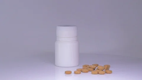 White bottle with brown tablets Stock Footage 129607135