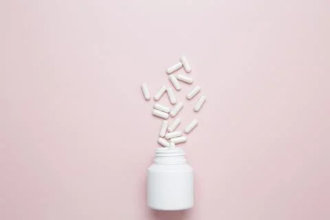 White bottle container with medication capsules. Concept of healthcare and me Stock Photos