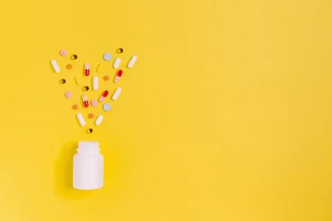 White bottle with different multicolored pills. Medicines from illness: heada Stock Photos