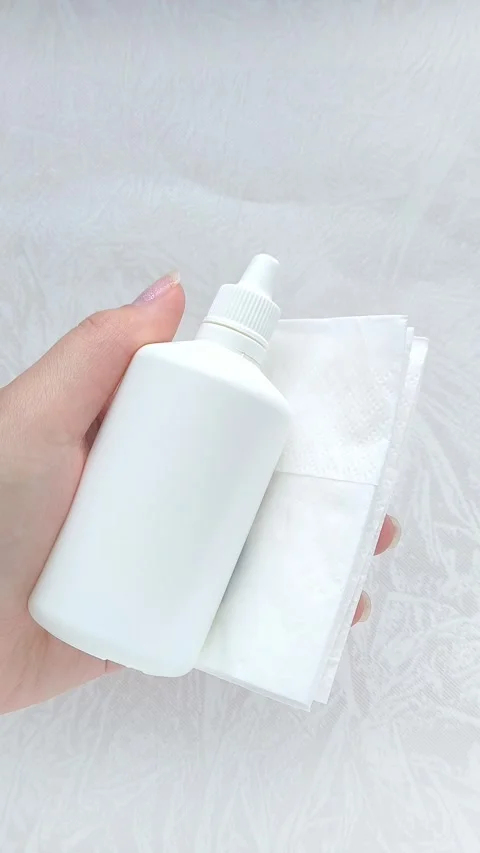 A white bottle of hydrogen peroxide and a napkin in a womans hand. The concept Stock Footage 316206552