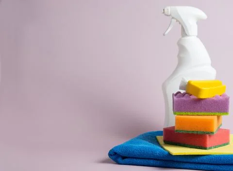 White bottle, rags, sponge on a purple background, A set for cleaning various Stock Photos