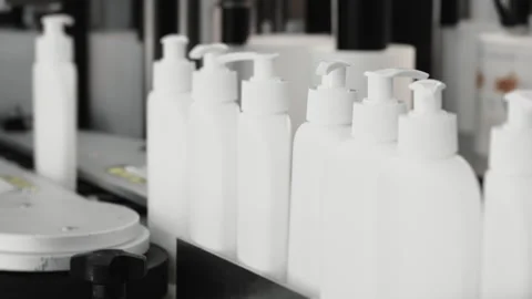 White bottles with a dispenser move along a conveyor. Video stock 283428602