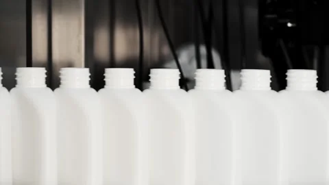 White bottles move along a conveyor to be filled. Stock Footage 283428664