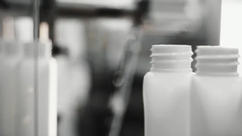 White bottles move along a conveyor to be filled. Stock Footage 283561006