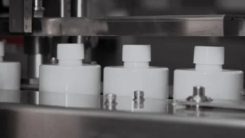 White bottles move along a conveyor to be filled. Stock Footage 306576346