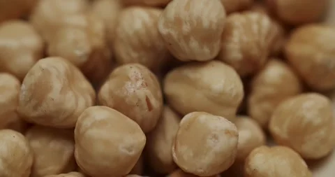 White bowl of peeled hazelnuts rotating Stock Footage 344317406