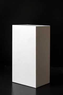White box on a black reflective background. Copy space. Stock Photos