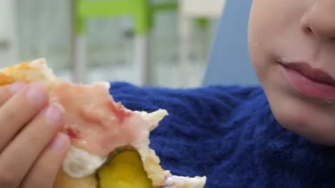 White boy aged 3-5 bites and chews a piece of pizza close-up. Stock-Footage 291870590