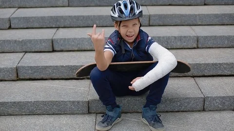 White boy with broken arm makng the rock sign Stock Footage