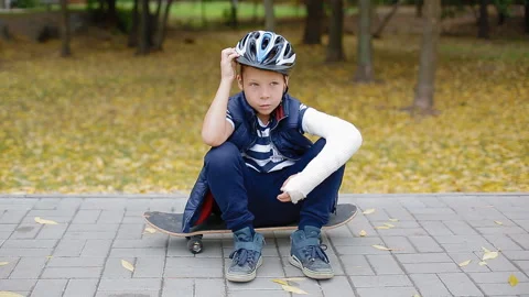 White boy with broken arm put of his helmet Stock Footage 91320229