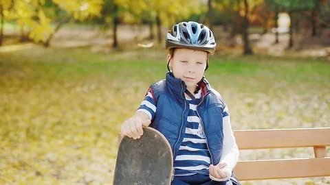White boy with broken arm sitting with skate Stock Footage 83269362