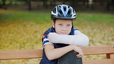 White boy with broken arm sitting with skate Stock Footage 83993310