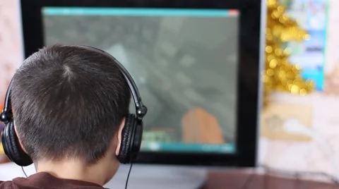 White boy in headphones playing the computer game Stock Footage 60789207