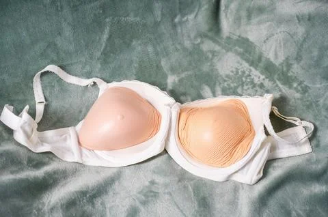 White bra with silicone external breast prosthesis inserts on the sofa Stock Photos