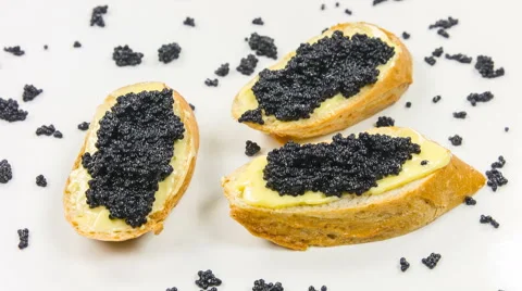 White bread with butter and black caviar as a sandwich. Close-up rotation. Video stock 63612089