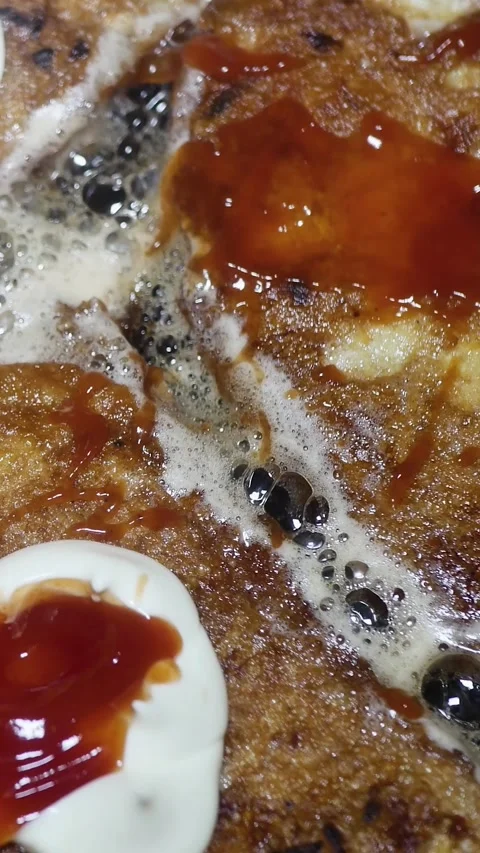 White bread with egg, mayonnaise, and ketchup frying in sunflower oil in a h Stock Footage 348486200