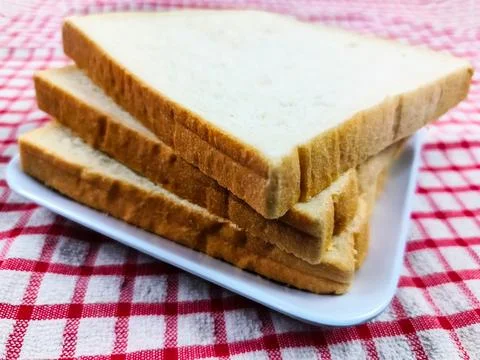 White bread on a plate and ready to be served with various types of jam to .. Stock Photos