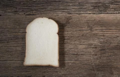 White bread slice isolated on wood background. Stock Photos