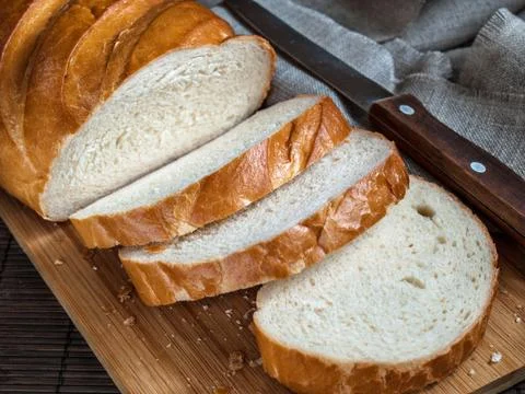 White bread sliced into pieces on a kitchen board Stock Photos