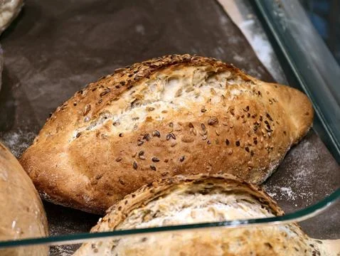 White bread topped with seeds displayed in the bread section of a supermark.. Stock Photos