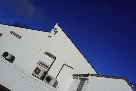 White Brick Building With Air Conditioning Units Against Blue Sky In Leeds, Stock Photos