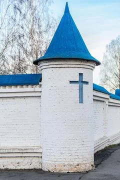 White brick monastery wall with blue-roofed towers and blue cross Stock-Fotos