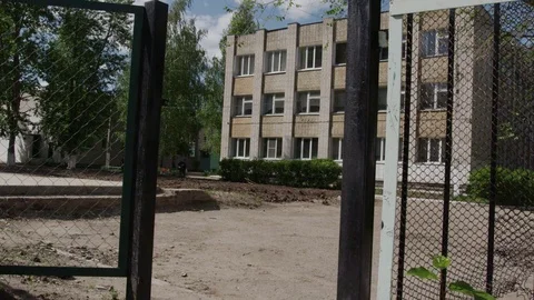 White brick school building with black fence Stock Footage 99643491