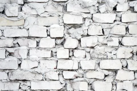 White brick wall background. gray uneven wall with pieces of cement between b Stock Photos
