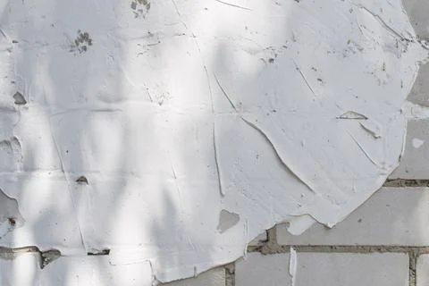White brick wall background with partial plaster and tree shadow. Stock-Fotos