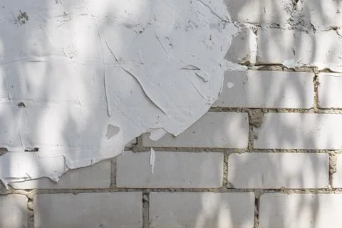 White brick wall background with partial plaster and tree shadow Stock-Fotos