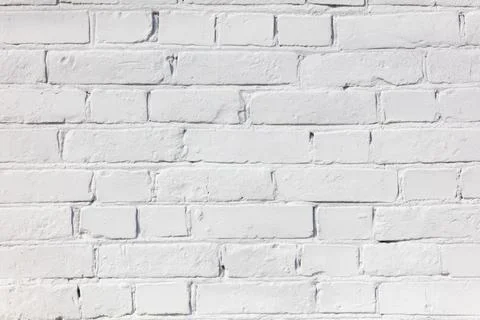 A white brick wall with a few bricks missing Stock Photos