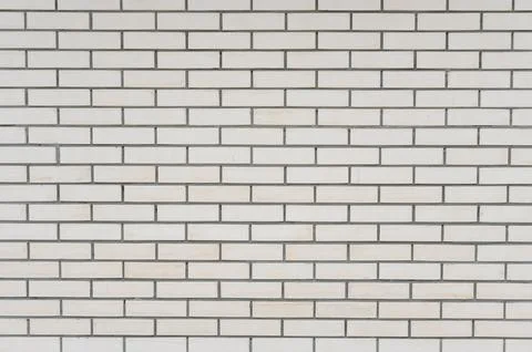 White brick wall with gray grout lines in a modern interior setting Stock Photos