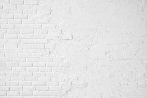 White brick wall half covered with stucco. Stock Photos