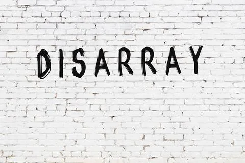  White brick wall with inscription disarray handwritten with black paint Stock Photos