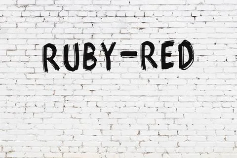  White brick wall with inscription ruby-red handwritten with black paint 스톡 사진