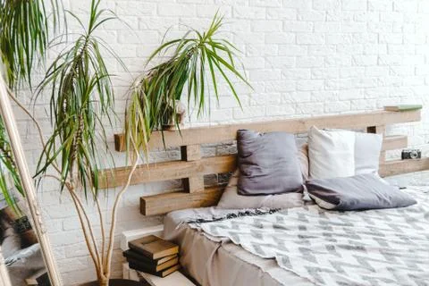White brick wall interior with mirror, pallets bed and pillows Stock Photos