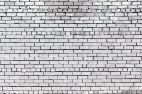 White brick wall with small cracks and small spots. Stock Photos