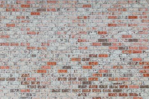 White brick wall with some pink and orange bricks. Stock Photos