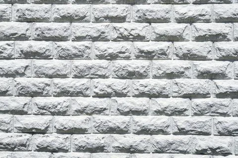 A white brick wall with a white brick in the middle Stock Photos