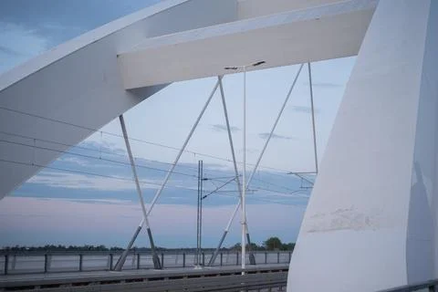 White bridge structure framing railway tracks over water in Novi Sad, Serbia 库存照片