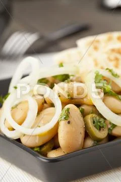 A white broad bean salad with olives and onions served with pita bread Stock Photos