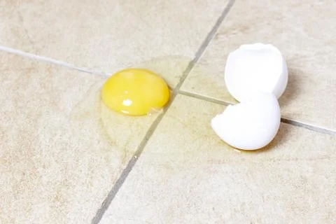 White broken egg on the kitchen floor Stock Photos