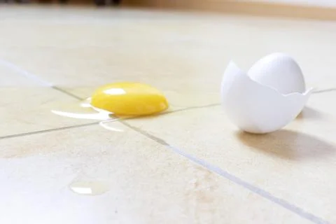 White broken egg on the kitchen floor Stock Photos