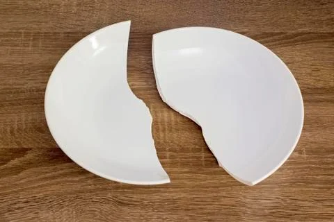 White broken plate on the table Stock Photos