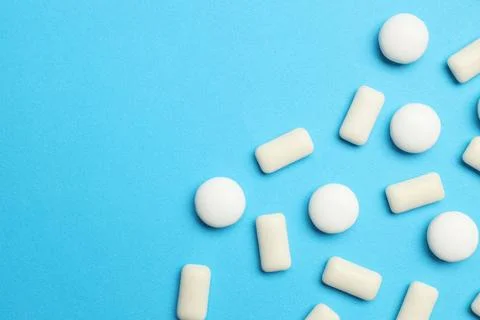 White bubble gums on blue background, flat lay. Space for text Stock Photos