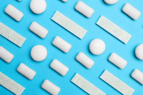White bubble gums on blue background, flat lay Stock Photos